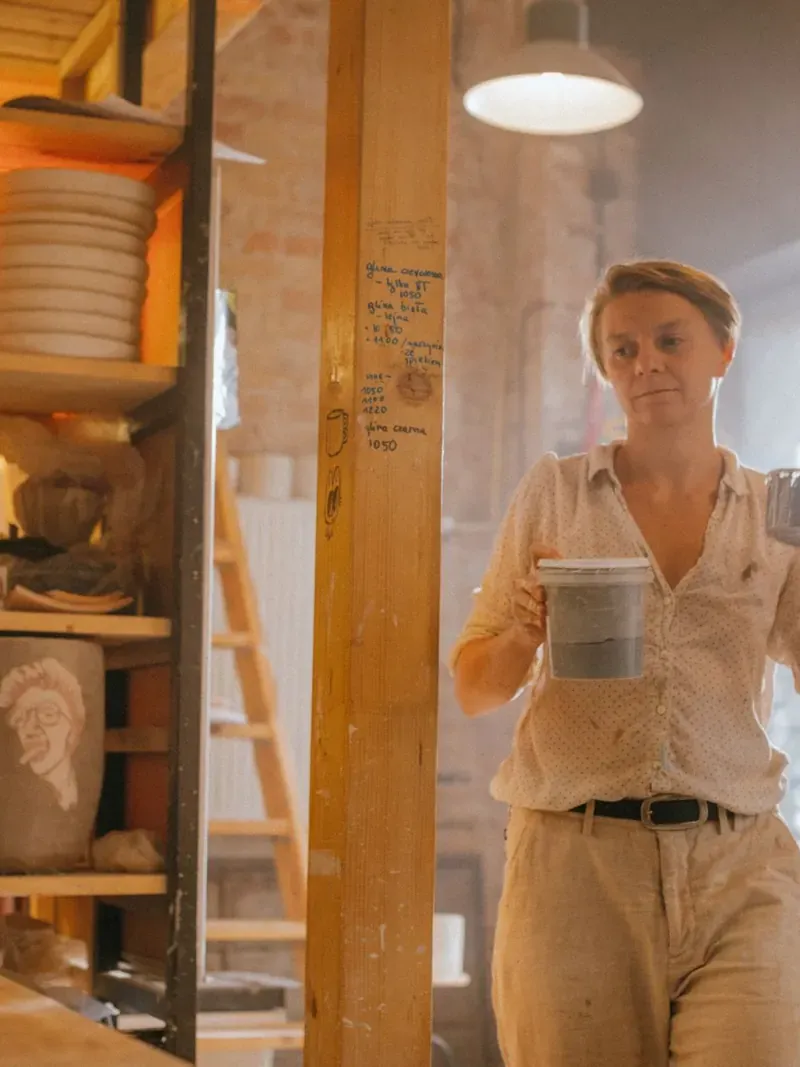 Une céramiste dans son atelier, entourée de pièces tournées à la main